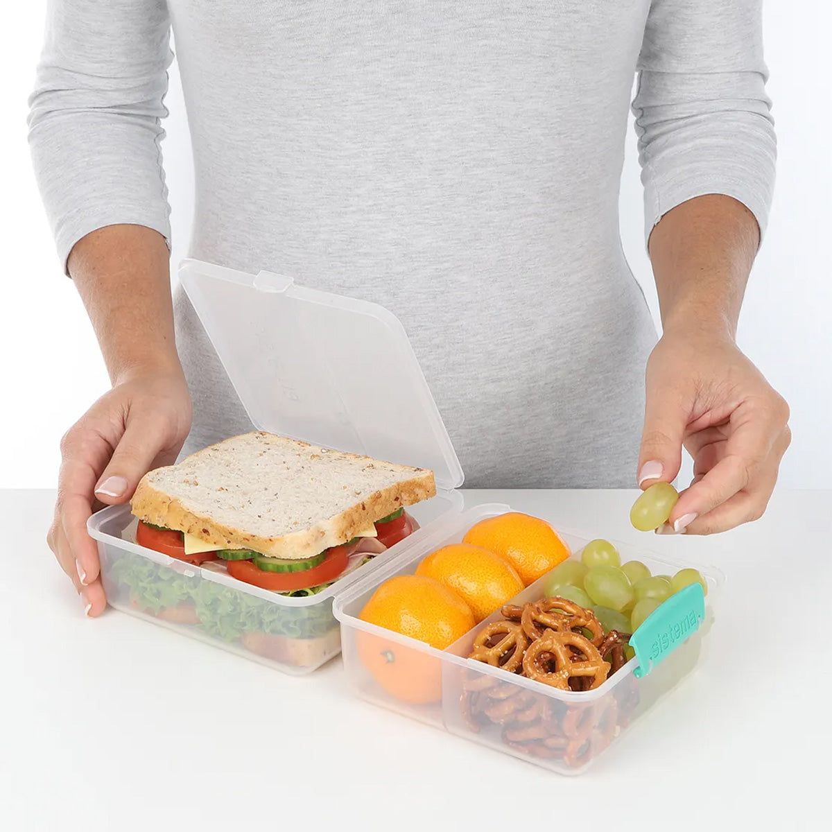 A photo of the Sistema 1.4L Lunch Cube TO GO, in clear, transparent. Image shows packed lunch.