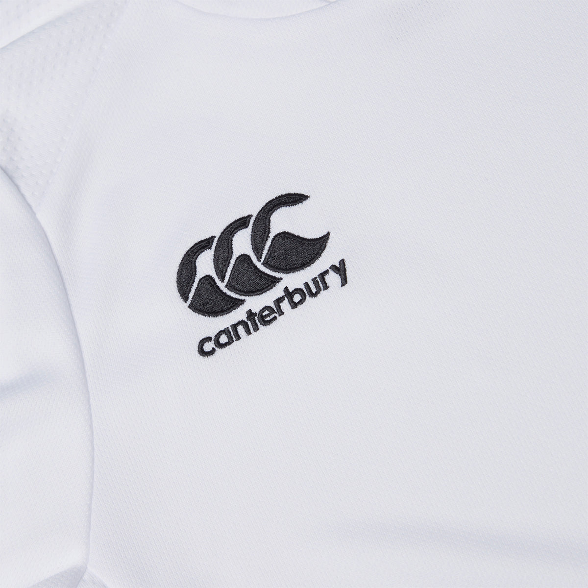 Photo of the Canterbury Club Dry Tee Junior in White, close up detail of embroidered Canterbury logo